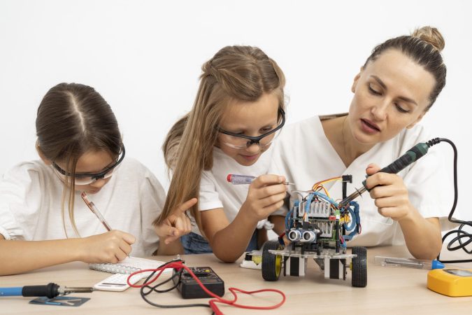 girls-female-teacher-doing-science-experiments-together-with-robotic-car