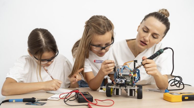 girls-female-teacher-doing-science-experiments-together-with-robotic-car